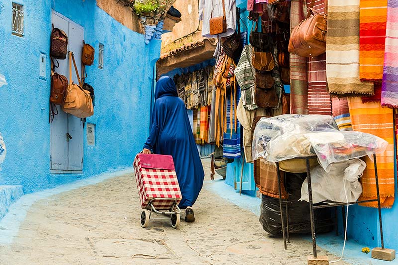 زنی با چرخ خرید در بازار شهر شفشاون مراکش