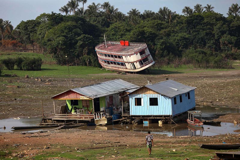 خانه‌های شناور و یک قایق سرگردان پس از آتش سوزی و خشکسالی در آمازوناس برزیل؛ منبع: theatlantic، عکاس: Michael Dantas
