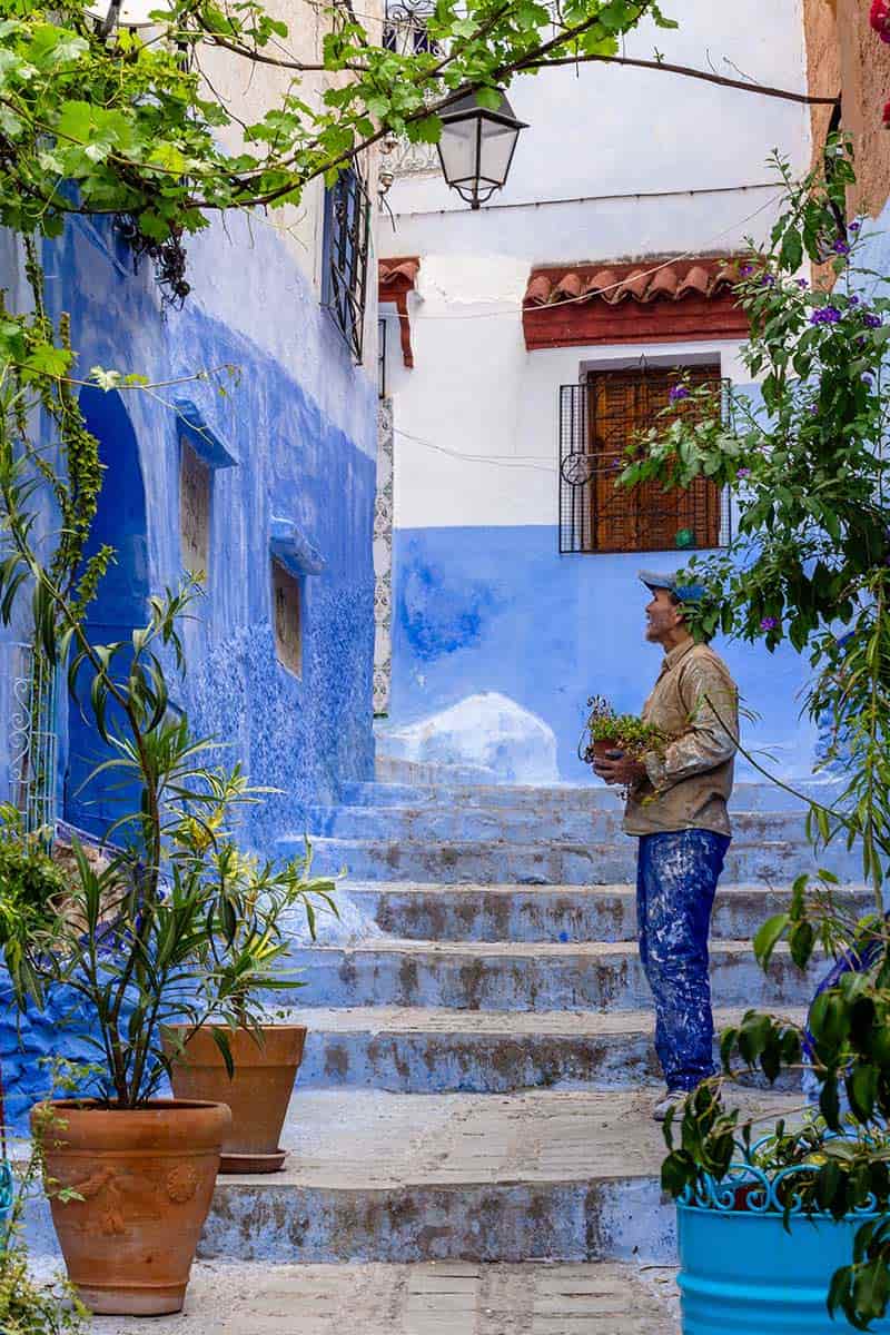 مردی با گلدانی در دست در شهر شفشاون مراکش