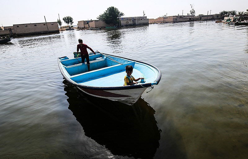 مرد و کودکی روستایی در قایق؛ منبع عکس: tasnim news؛ عکاس: مهدی پدرام خو