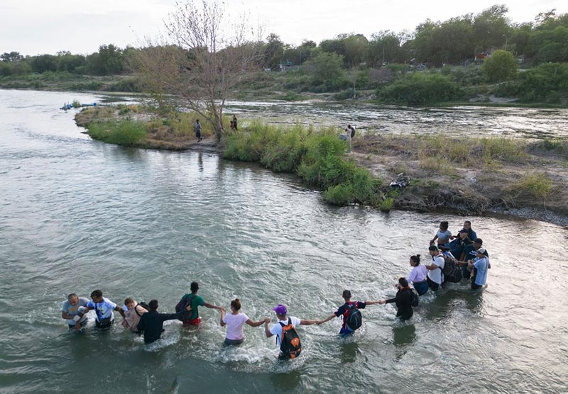 گذر مهاجران از رودخانه‌ای در مرز امریکا و مکزیک؛ منبع: theatlantic، عکاس: Andrew Caballero-Reynolds 