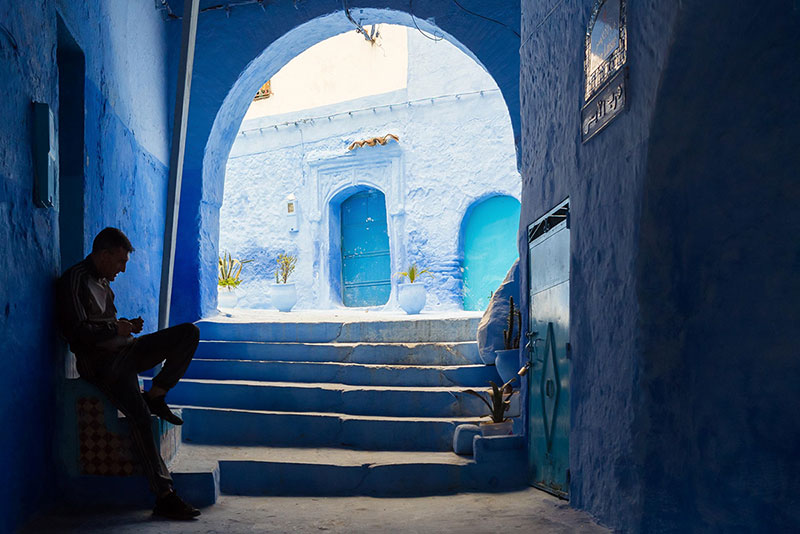 مردی نشسته بر سکویی در شهر شفشاون مراکش