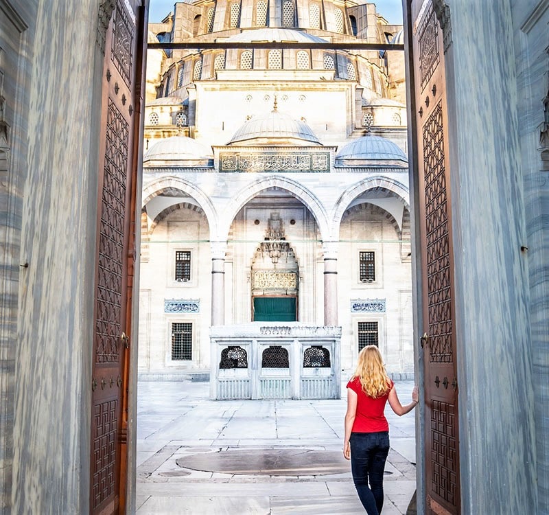زن گردشگر در ورودی مسجد سلیمانیه استانبول، منبع عکس:‌walkmyworld.com، عکاس: ناشناس