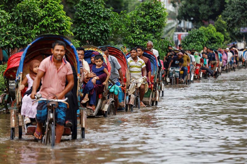 گذر مسافران پس از باران های شدید بنگلادش؛ منبع: theatlantic، عکاس: Mohammad Ponir Hossain