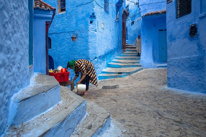 زنی در حال شستشوی کوچه در شهر شفشاون مراکش