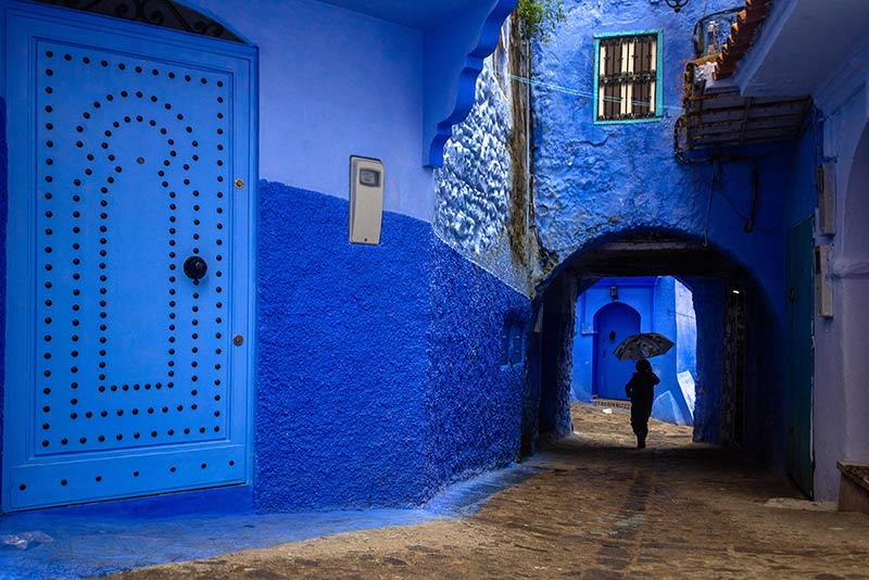 عبور فردی با چتر از دالان‌های شهر شفشاون مراکش