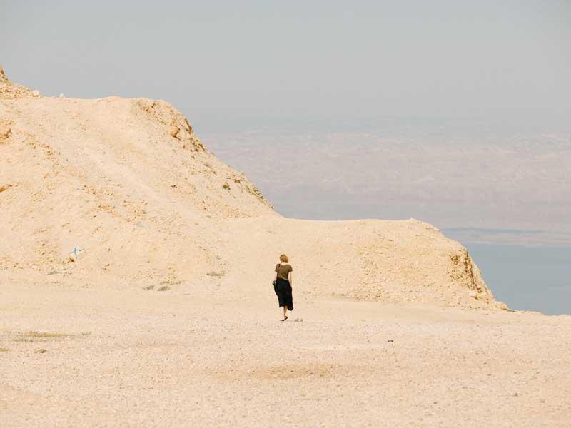 عبور زنی از صخره‌های ساحلی در اردن