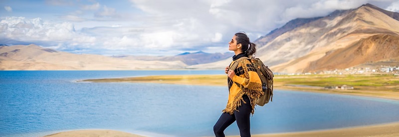 خانمی با کوله کنار دریاچه؛ منبع: www.veenaworld.com
