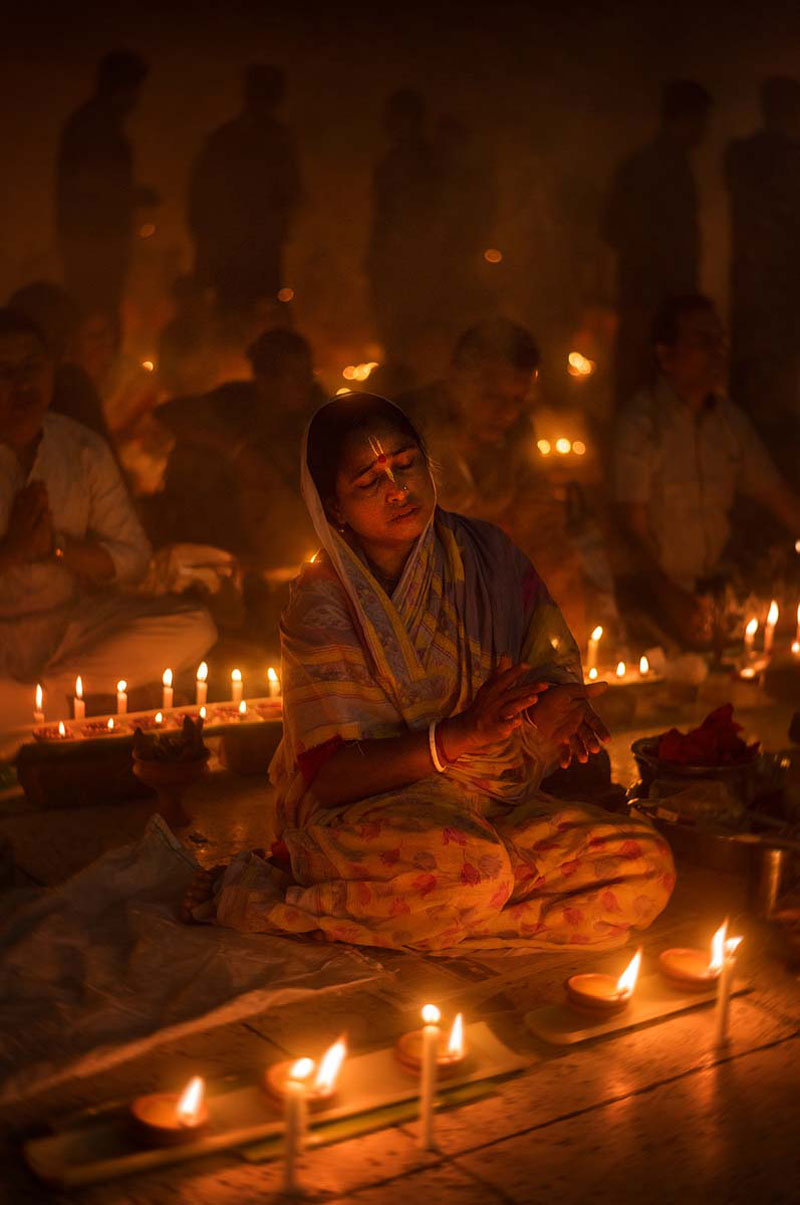زنی در جشن راخر اوپوپاش در کنار چنیدن شمع روشن
