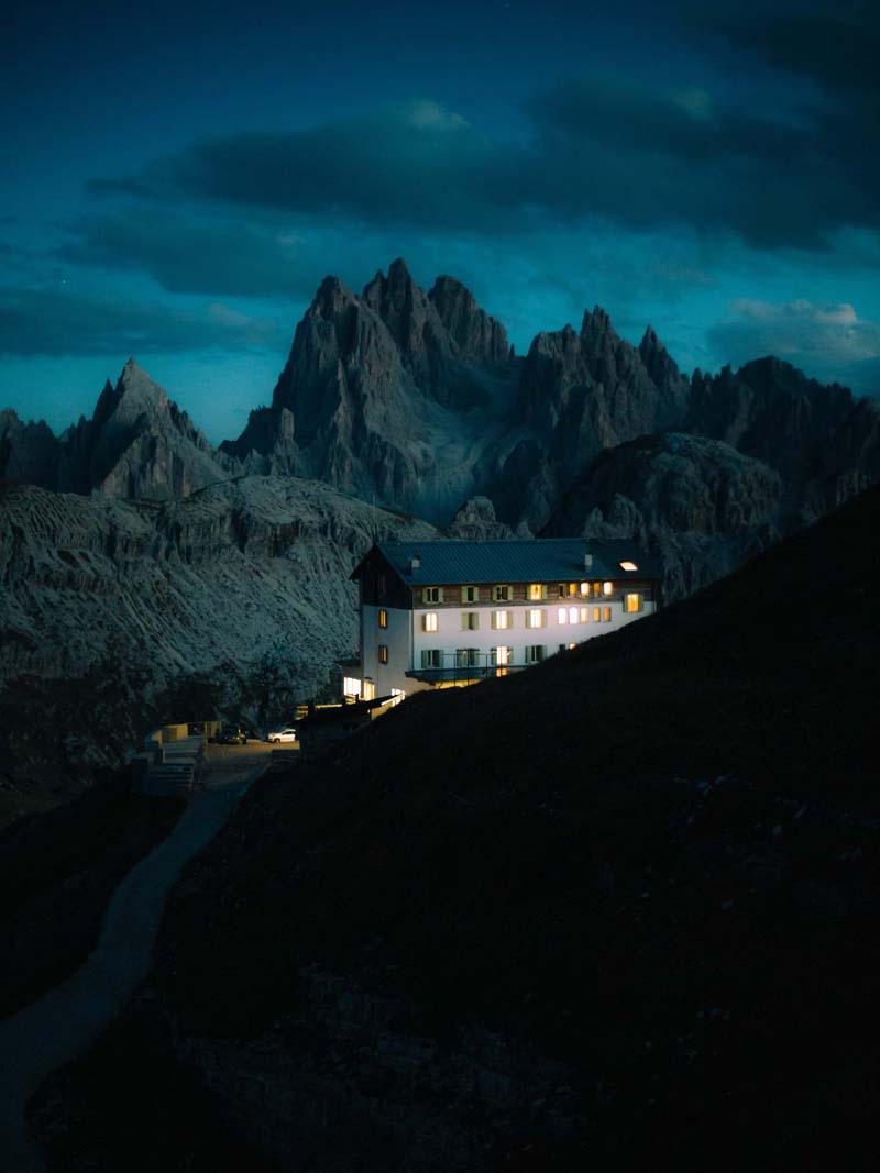 خانه‌ای در میان کوهستان اروپایی در شب 
