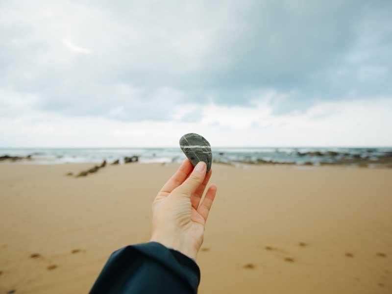 نمایش سنگی در دست در ساحل دریا