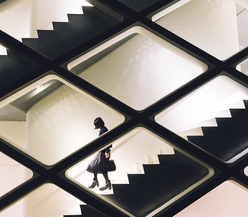 عکس سیاه و سفید از تردد یک زن از روی پله های ساختمان