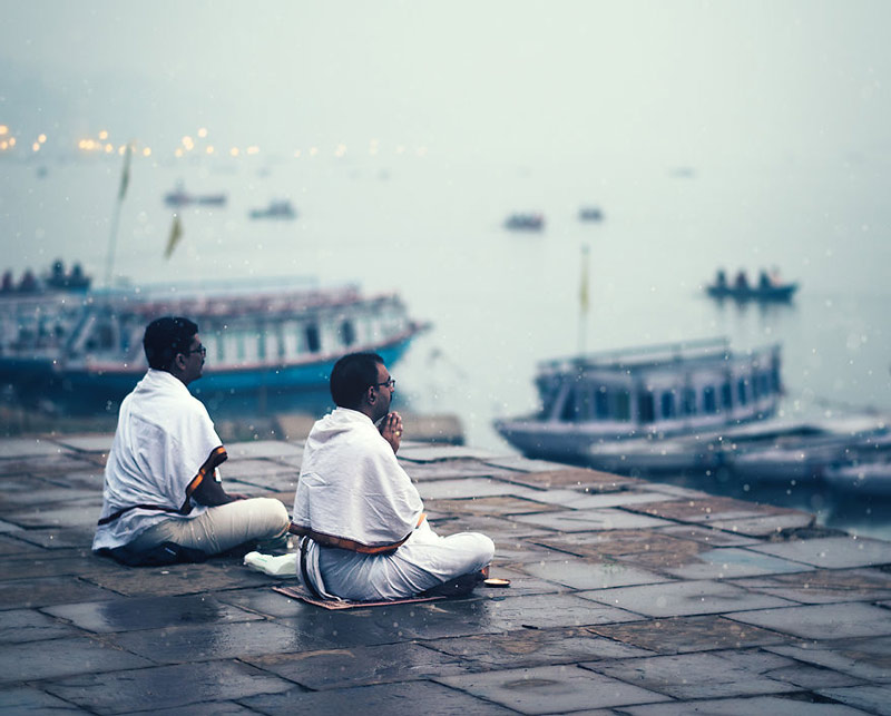 دو مرد سپید پوش بنارسی کنار آب و در حال عبادت