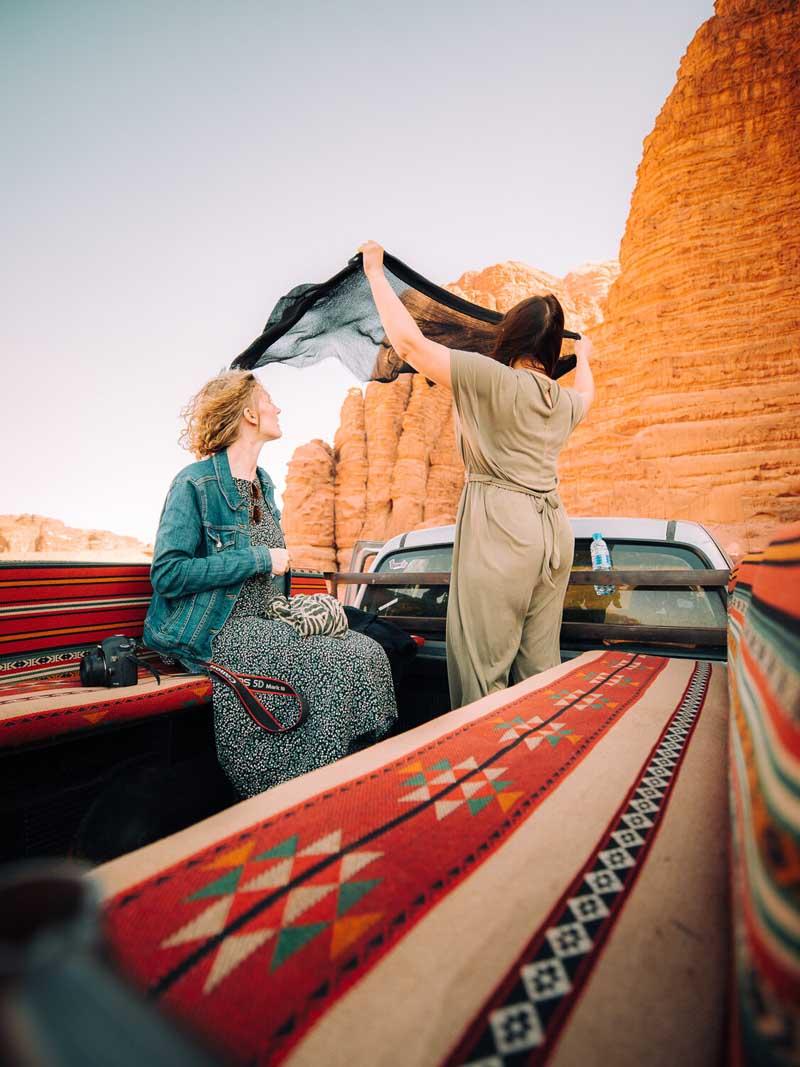 دو زن گردشگر سوار بر خودرویی در صحرای اردن
