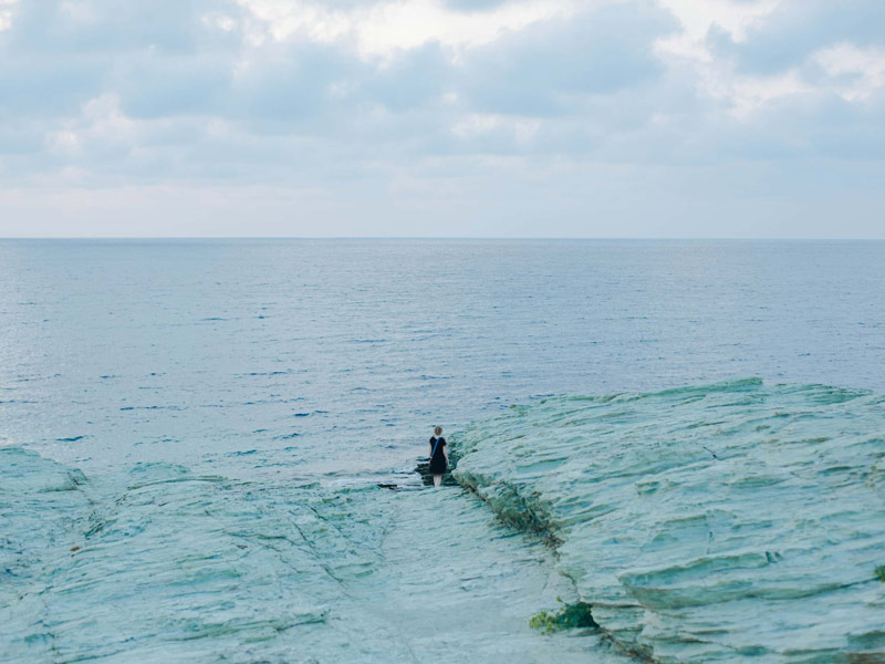 زنی ایستاده در میان امواج دریا