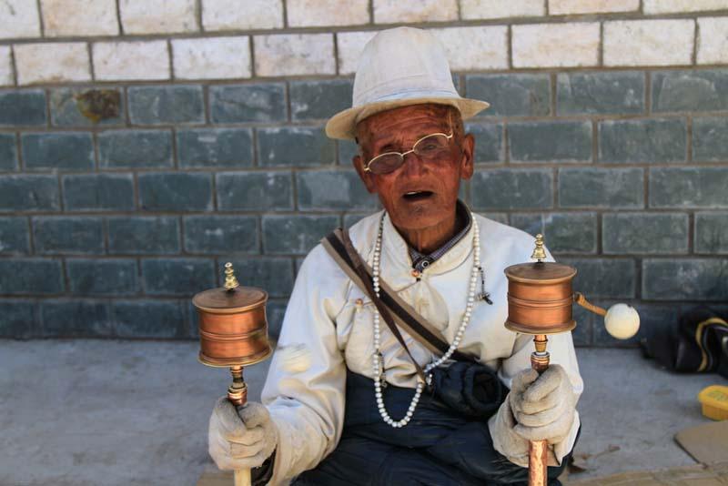 مرد آسیایی با دو جغجغه سنتی در دست