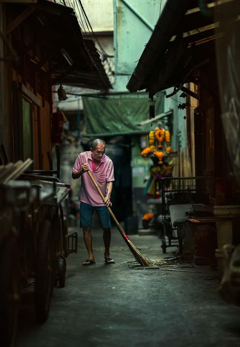 مردی در حال جارو کشیدن خیابانی در بانکوک