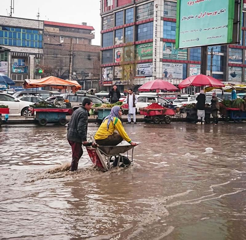 دو مرد در خیابان آب گرفته در افغانستان