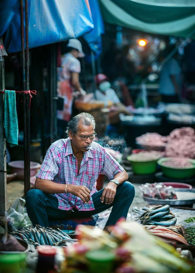 مرد فروشنده تایلندی در حال کشیدن سیگار