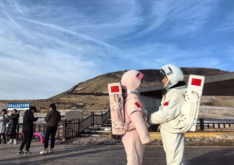 گردشگران با لباس فضانوردی در ژئوپارک آتشفشانی اولان هادا (Ulan Hada) در چین