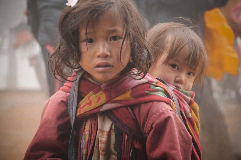 دختربچه آسیایی با کودکی بر پشت 