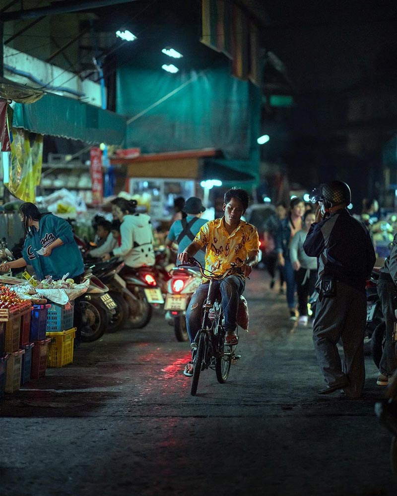 مرد موتورسوار در حال عبور از خیابانی در شهر چیانگ مای هنگام شب 