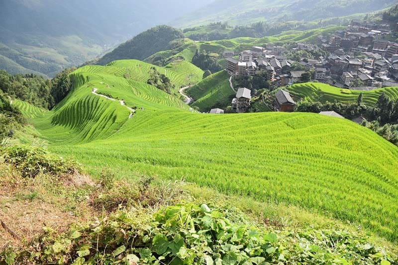 تپه‌ای سبز و کلبه‌هایی قدیمی در روستای پینگان  