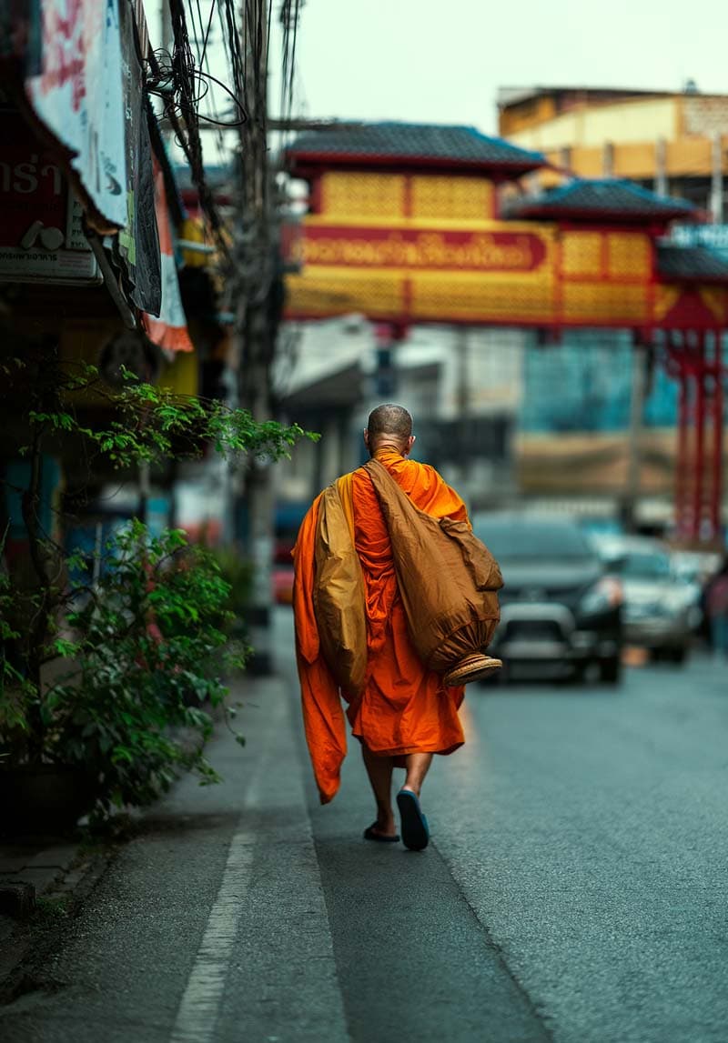 راهبی با کوله پشتی در خیابانی در چیانگ مای