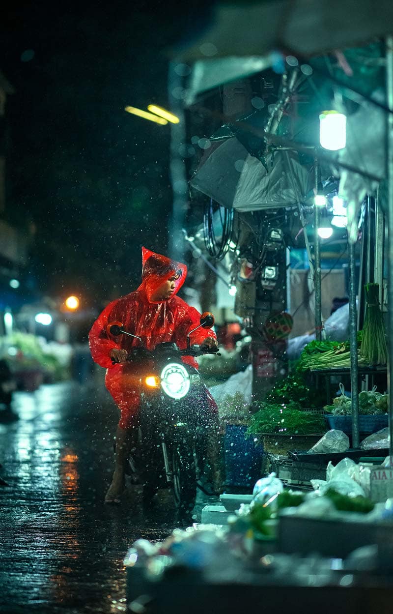مردی با بارانی قرمز روی موتور در شهر چیانگ مای