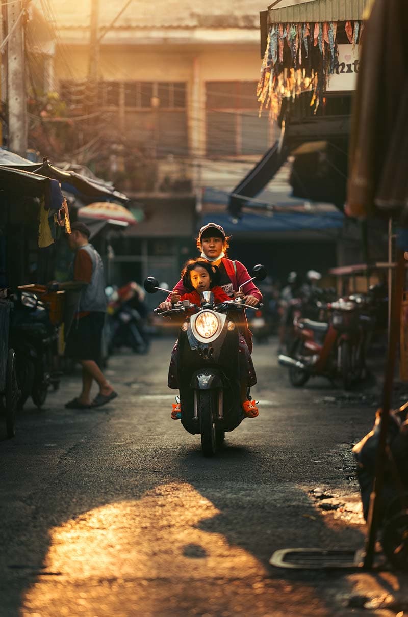 زن موتورسوار و کودکش در خیابانی در شهر چیانگ مای تایلند