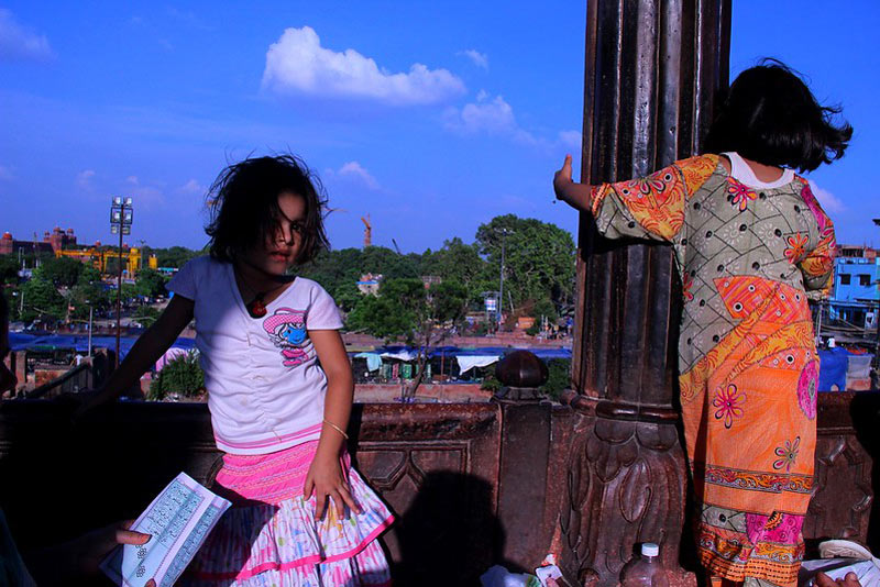 دو کودک دختر با لباس رنگی در ایوانی در مسجد جامع دهلی