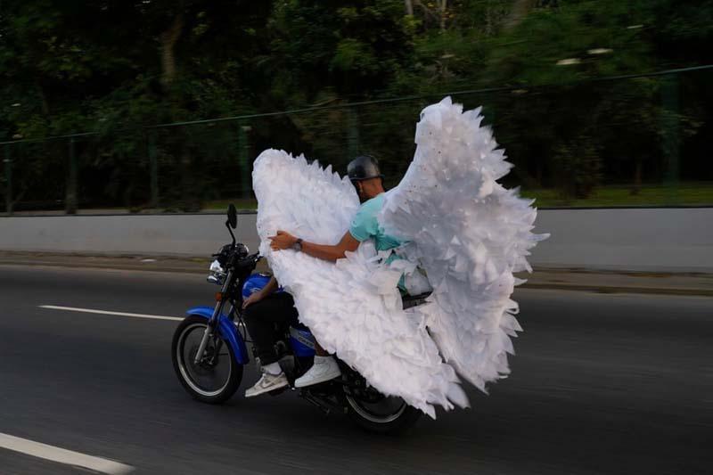 حمل بال‌های لباس بر موتور در طول جشن‌های کارناوالی در کاراکاس، ونزوئلا