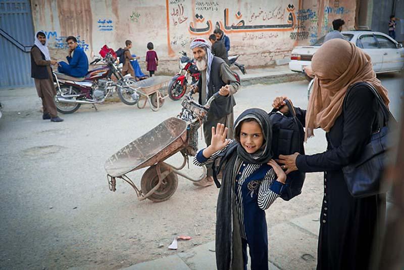 قرار دادن کوله‌پشتی در پشت دختر دانش‌آموز افغان