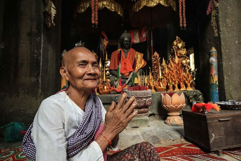 مرد آسیایی مقابل مجسمه بودا
