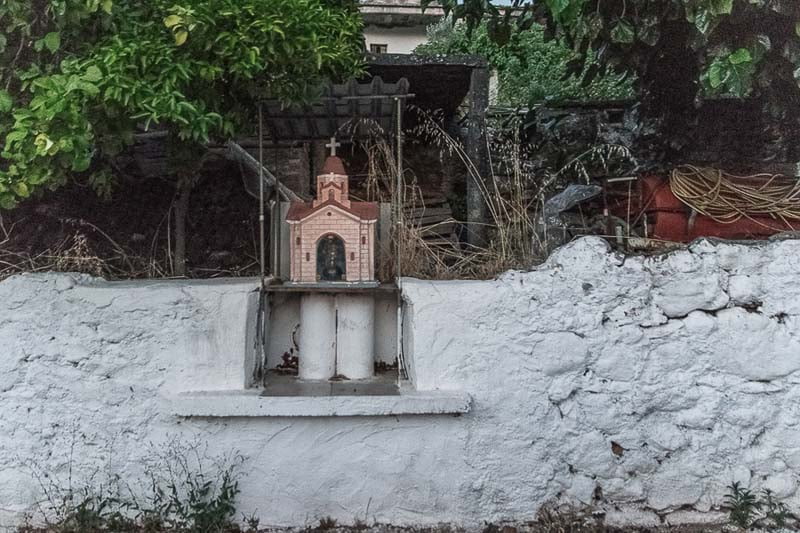 یک عبادتگاه بسیار کوچک در کنار دیوار جاده