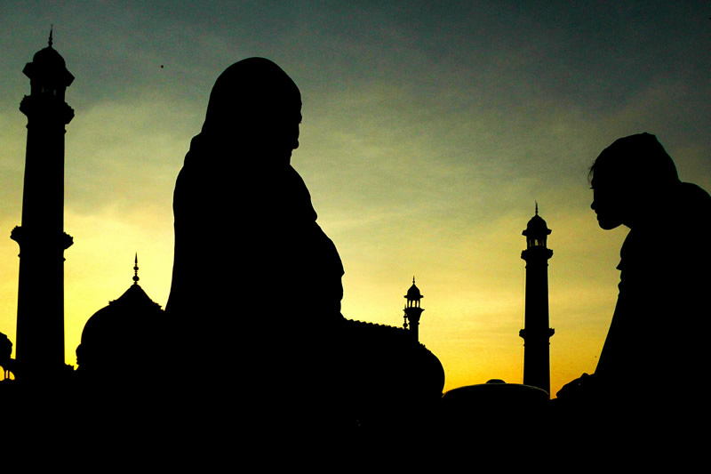 تصویر سایه‌ای زنان روبروی گنبد و بارو در غروب مسجد جامع دهلی
