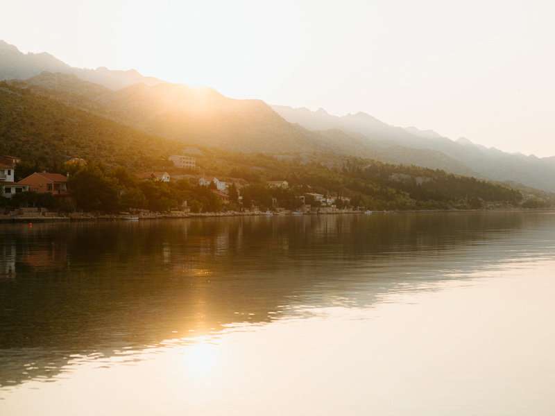 طلوع آفتاب در جزیره‌ای مسکونی کنار آب در اروپا