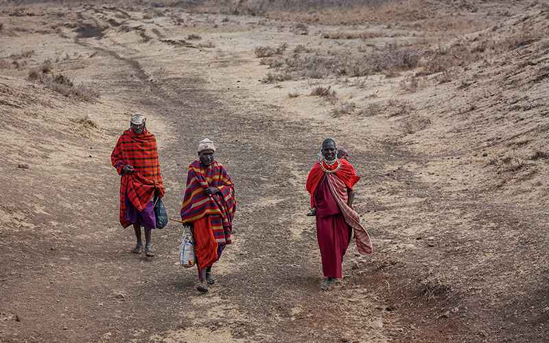 سه نفر از بومیان تانزانیا با لباس قرمز