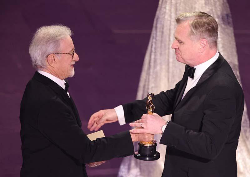 کریستوفر نولان (Christopher Nolan) هنگام دریافت اسکار بهترین کارگردانی از دست استیون اسپیلبرگ (Steven Spielberg)