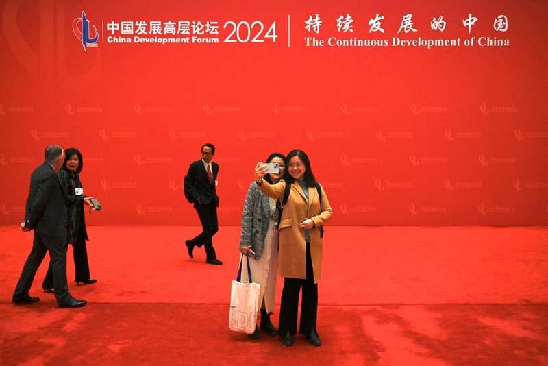 بازدیدکنندگان در یک انجمن توسعه ملی در چین برای گرفتن سلفی ژست می گیرند