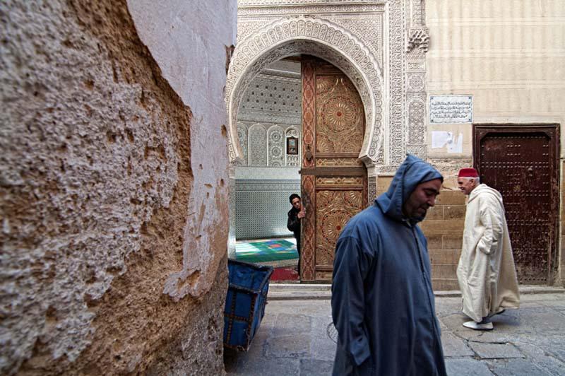 مردی با لباس آبی جلوی مسجدی در مراکش