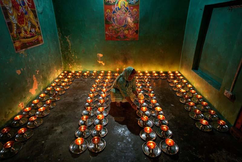 شمع روشن کردن یک عابد هندو در اولین روز جشن ناوراتری در یک معبد