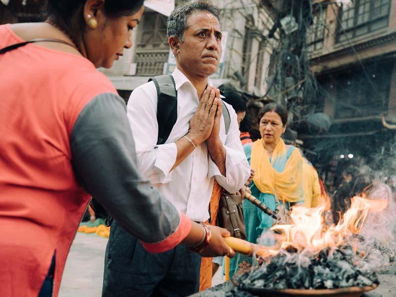 مرد هندی کنار آتش در حال دعا