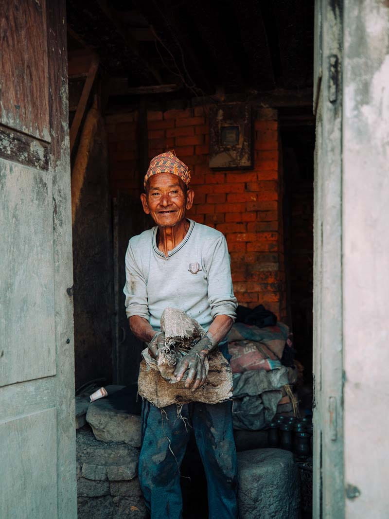 لبخند مرد کارگر نپالی در حال انجام کار