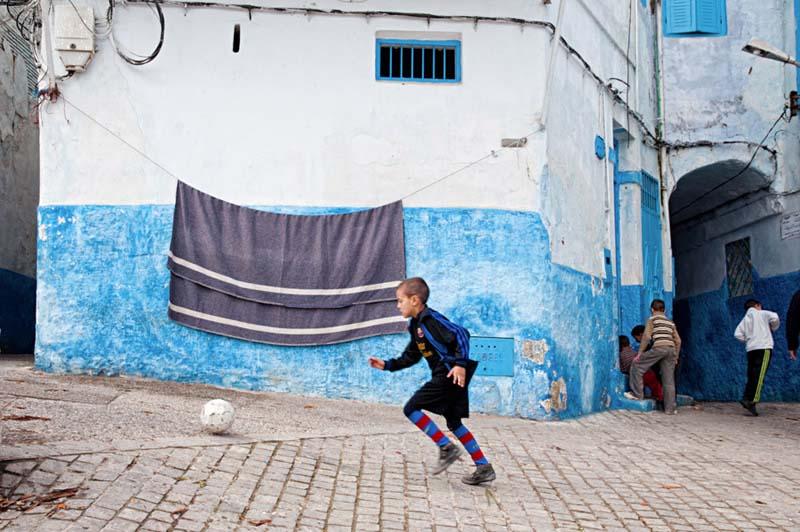 توپ بازی کودک مراکشی در کوچه آبی و سفید