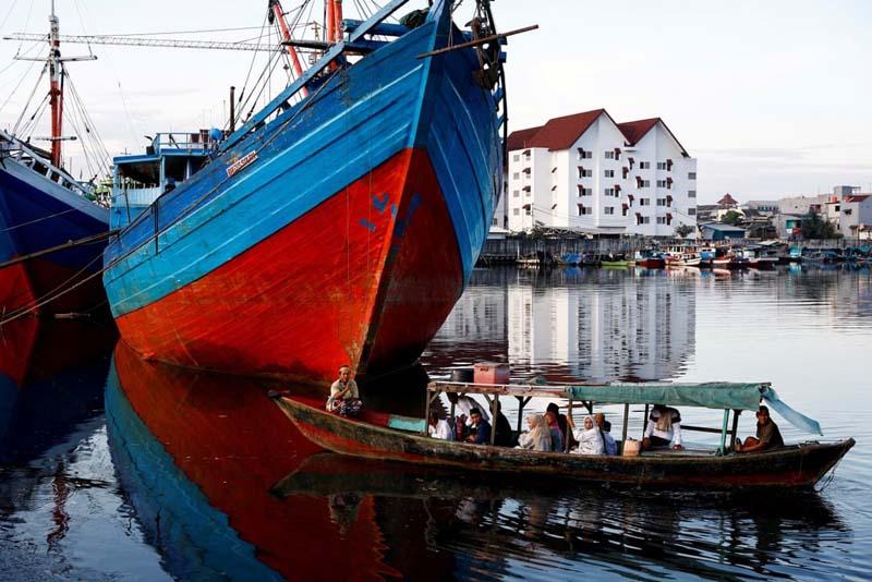 مسلمانان در جاکارتا اندونزی برای شرکت در نماز دسته جمعی عید فطر سوار بر قایق چوبی می شوند