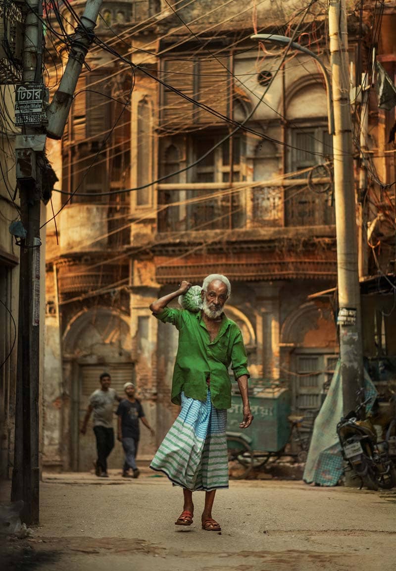 پیرمردی با لباس سبز در خیابان‌های داکا 
