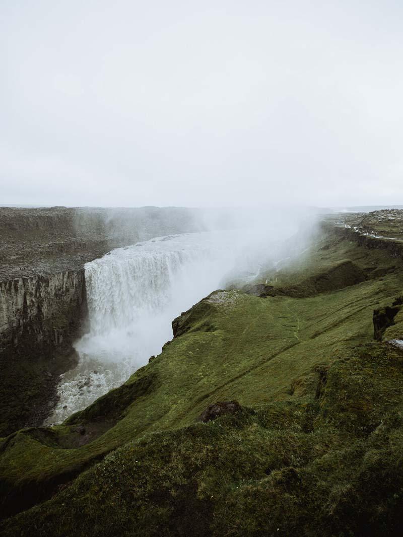 آبشاری زیر مه در دره‌ای در ایسلند