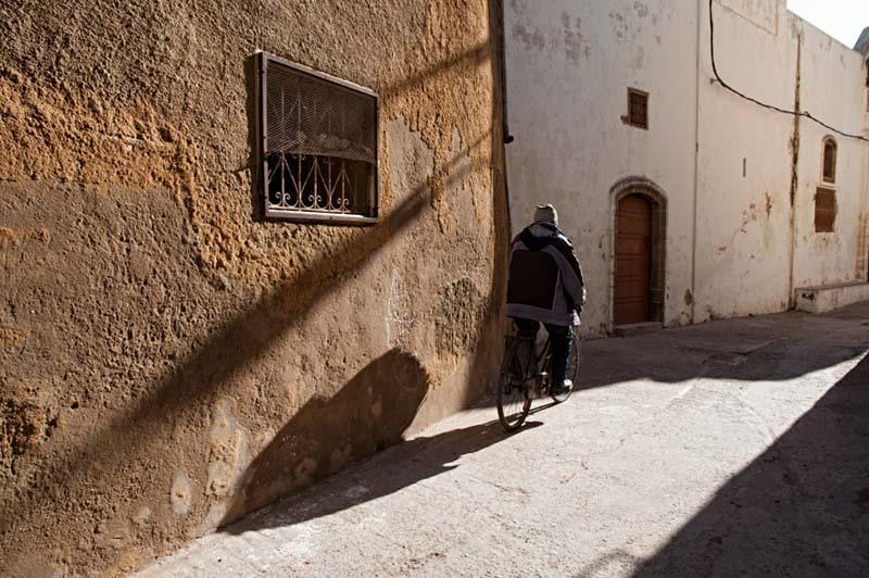 عبور مردی با دوچرخه از کوچه ای قدیمی در مراکش