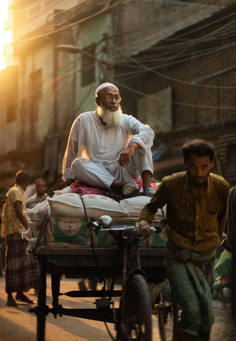 پیرمردی سوار بر گاری در خیابان‌های داکا